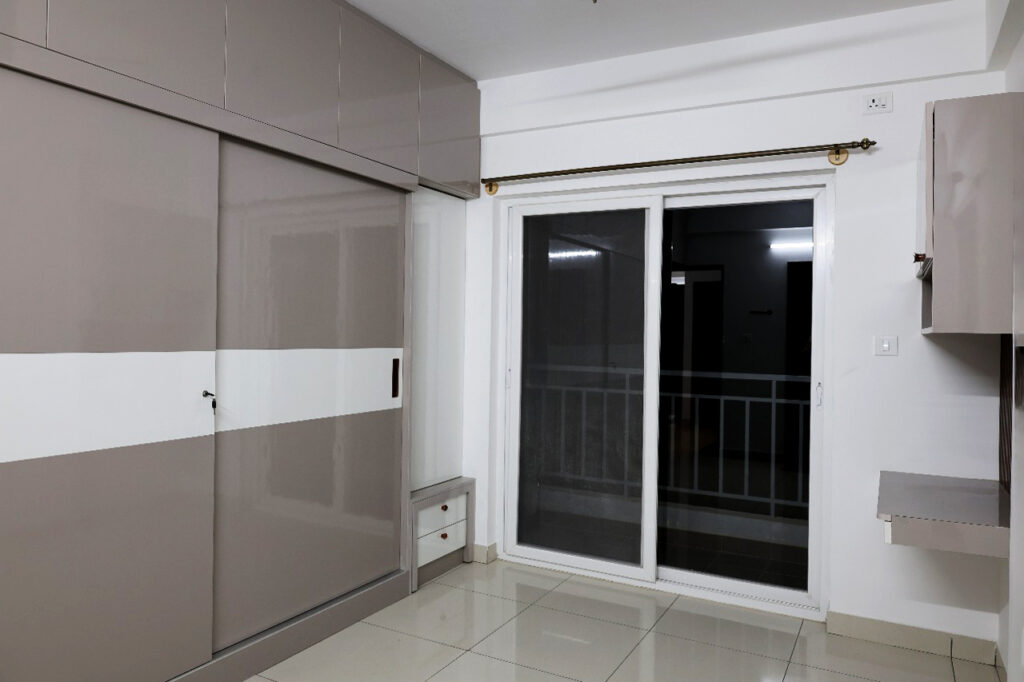 A stylish beige sliding wardrobe with a clean white accent panel.